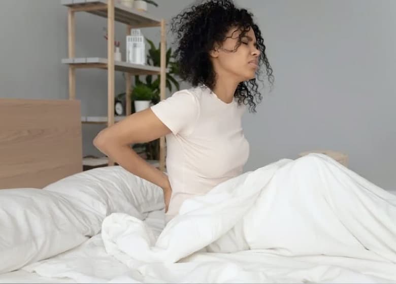 Femme qui ne se sent pas bien à son réveil sur son matelas